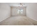 Spacious living area with neutral carpet, a large window, and ceiling fan at 4429 Sw 49Th Ave, Ocala, FL 34474