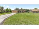 Beautiful single-story home with a long driveway and a lush green lawn at 5024 Sw 114Th Street Rd, Ocala, FL 34476