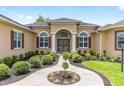 Inviting front entrance with elegant double doors and decorative landscaping at 5024 Sw 114Th Street Rd, Ocala, FL 34476