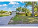 Inviting home featuring a green lawn, mature trees, and a convenient attached garage, ideal for Gathering living at 5581 Se 35Th St, Ocala, FL 34480