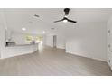 Bright living space with white walls, vinyl floors, fan, an open floor plan and views of the kitchen at 681 Sw Fig Tree Ln, Dunnellon, FL 34431