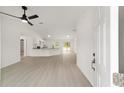 Bright, open-concept living space with white walls, vinyl floors, fan and a modern kitchen with granite counters at 681 Sw Fig Tree Ln, Dunnellon, FL 34431