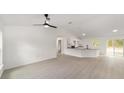 Bright living space with white walls, vinyl floors, fan, an open floor plan and sliding doors to the back at 681 Sw Fig Tree Ln, Dunnellon, FL 34431