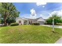 Charming single-story home with a well-manicured lawn and a two-car garage, set against a sunny sky at 8128 Sw 117Th Loop Loop, Ocala, FL 34481