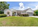 Inviting single-story home featuring arched windows, a well-kept lawn, and an attached two-car garage at 8128 Sw 117Th Loop Loop, Ocala, FL 34481