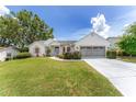 Single-story home with a well-manicured lawn and a two-car garage, radiating curb appeal under a bright sky at 8128 Sw 117Th Loop Loop, Ocala, FL 34481