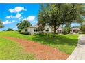 Expansive lawn with a mulch path and lush greenery surrounding the property at 9925 Sw 95Th Loop, Ocala, FL 34481