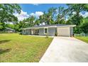 Exterior view of home with an attached garage and long driveway at 1133 Nw 122Nd Pl, Citra, FL 32113