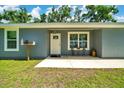 Close-up of the home's entrance featuring a charming porch and manicured lawn at 1133 Nw 122Nd Pl, Citra, FL 32113