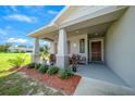 Inviting front porch with decorative accents and comfortable seating, enhancing curb appeal at 11330 Sw 61St Cir, Ocala, FL 34476