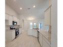 Well-lit kitchen with stainless steel appliances, stone countertops, and ample cabinet space at 12384 Sw 96Th Ln, Dunnellon, FL 34432
