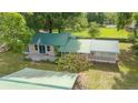 Aerial view of home with a green metal roof, a spacious yard and nearby horse pastures at 1501 Ne 97Th Street Rd, Anthony, FL 32617