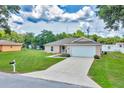 Charming home with a spacious lawn, long driveway, and attached two-car garage at 1689 Ne 161St Pl, Citra, FL 32113