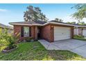 Charming single-story brick home with a well-manicured lawn and a two-car garage at 2127 Ne 38Th Ter, Ocala, FL 34470