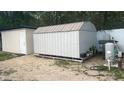 Backyard view of storage sheds with access to water features and white privacy fence at 43 Pine Run, Ocala, FL 34472