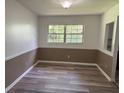 Neutral dining room with wainscotting, new floors, and bright natural light from the large window at 4701 Ne 9Th St, Ocala, FL 34470