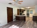 Open-concept kitchen with dark cabinets, new floors, and appliances in a cozy layout at 4701 Ne 9Th St, Ocala, FL 34470