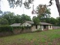 Property's exterior with stone accents surrounded by a wooden fence and mature trees at 6141 Nw 64Th Ct, Ocala, FL 34482
