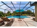 Relaxing screened pool area with chaise lounge, outdoor umbrella and lovely water feature at 7814 Sw 97Th Cir, Ocala, FL 34481