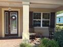 Inviting front porch with decorative door and chairs at 8303 Sw 78Th Cir, Ocala, FL 34476