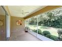 Relaxing screened patio with ceiling fan and view of lush backyard landscaping at 8303 Sw 78Th Cir, Ocala, FL 34476
