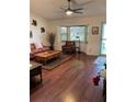 Spacious living room with hardwood floors, natural light from bay window, and a ceiling fan at 8450 Sw 90Th St # D, Ocala, FL 34481