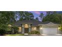 Inviting home with a classic arched entryway, a well-manicured lawn, and a convenient two-car garage at 8605 Sw 209Th Court Rd, Dunnellon, FL 34431