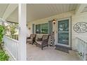 Inviting front porch with chairs, side table, and decorative nautical compass at 8841 Sw 91St St # A, Ocala, FL 34481