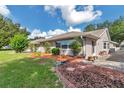 Well-maintained home exterior with manicured landscaping, beautiful brick accents, and lush green lawn at 9069 Sw 91St Cir, Ocala, FL 34481