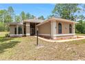 Inviting single-story stucco home featuring arched windows, manicured landscaping, and a neatly maintained lawn at 9180 Sw 202Nd Avenue Rd, Dunnellon, FL 34431