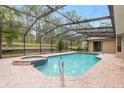 Relaxing screened pool and spa area with brick pavers and private wooded views, perfect for enjoying sunny days at 9180 Sw 202Nd Avenue Rd, Dunnellon, FL 34431