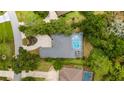 Aerial view of a house with a kidney-shaped pool with a fountain, surrounded by trees at 9213 Sw 197Th Cir, Dunnellon, FL 34432