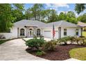 Charming home featuring a well-manicured lawn, a long driveway and an american flag at 9213 Sw 197Th Cir, Dunnellon, FL 34432