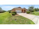 View of home featuring a two-car garage, manicured lawn, and colorful shrubs at 9236 Sw 91St Court Rd, Ocala, FL 34481