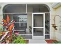The screened porch includes seating and potted plants, offering a relaxing transition to the home's front entry at 611 Allenwood Loop, The Villages, FL 32162