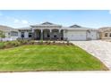 Lovely single-story home boasting lush landscaping, an attached three-car garage, and charming stone accents at 10032 Sw 85Th Place Rd, Ocala, FL 34481