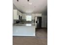 An open concept kitchen features white cabinets, granite countertops, and stainless steel appliances at 10385 Se 125Th Ln, Belleview, FL 34420