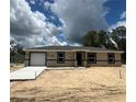 New construction shows a single story home with an attached garage and a modern design at 10401 Se 125Th Ln, Belleview, FL 34420