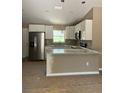 New kitchen features white cabinets, granite countertops, and stainless steel appliances at 10401 Se 125Th Ln, Belleview, FL 34420