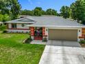 Charming single-story home boasts a colorful trim, a well-manicured lawn and an inviting, covered front porch at 10459 Sw 62Nd Ct, Ocala, FL 34476