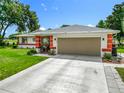 Charming single-story home with a well-manicured lawn, two car garage and a colorful, covered front porch at 10459 Sw 62Nd Ct, Ocala, FL 34476