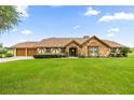 Beautiful single-Gathering home with stone facade, neutral stucco, and a well-maintained lawn at 12131 Ne 10Th Ter, Ocala, FL 34479