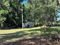 View of a backyard shed in a grassy, tree-filled yard at 14 Count Fleet Dr, Ocala, FL 34482