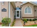 Inviting front entrance with a decorative door, lush plants, and exterior lighting at 15549 Sw 11Th Terrace Rd, Ocala, FL 34473