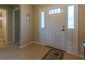 Bright entryway featuring a white front door with decorative glass and tiled flooring, leading into the home at 16215 Sw 15Th Ct, Ocala, FL 34473