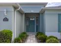 Inviting front entrance with stone walkway and lush landscaping leading to the home's teal-colored door at 16215 Sw 15Th Ct, Ocala, FL 34473