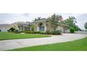 Lovely one-story home with lush green lawn, mature landscaping and a large, paved driveway leading to the garage at 17034 Florence View Dr, Montverde, FL 34756