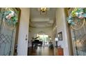 Grand foyer featuring high ceilings, hardwood floors, decorative moldings, and an elegant piano at 17034 Florence View Dr, Montverde, FL 34756