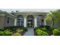 Inviting front entrance with arched windows, columns, mature landscaping, and a walkway leading to the front door at 17034 Florence View Dr, Montverde, FL 34756