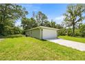 Spacious backyard showing the home's exterior and attached garage on a sunny day at 1708 Nw 27Th Ave, Ocala, FL 34475